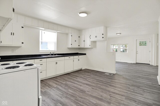 952 N Concord St, Indianapolis, IN 46222 - kitchen featuring electric range, light wood-type flooring, white cabinets, and dark countertops