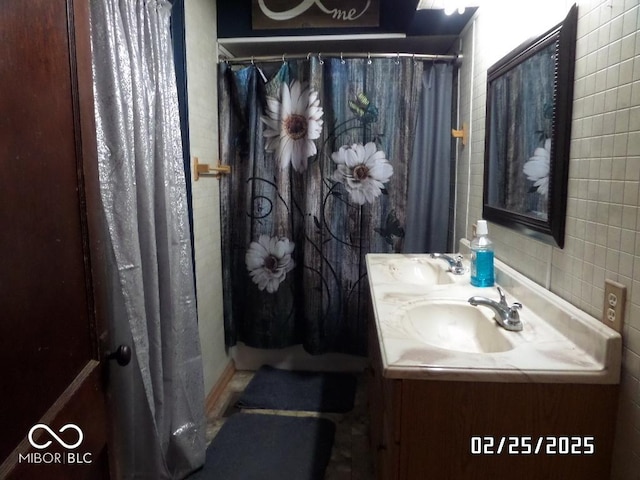 bathroom with double vanity, curtained shower, and a sink