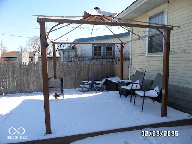 snow covered patio featuring fence