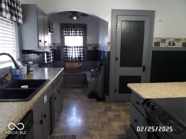 kitchen featuring light countertops, a sink, and gray cabinetry