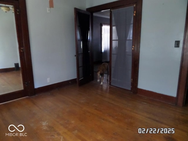 spare room with dark wood finished floors and baseboards