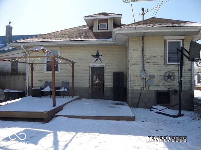 snow covered property featuring a shingled roof