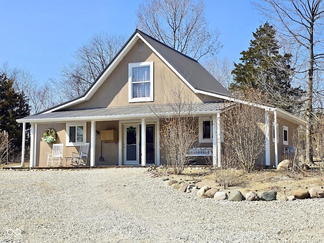 farmhouse featuring a standing seam roof, covered porch, and metal roof