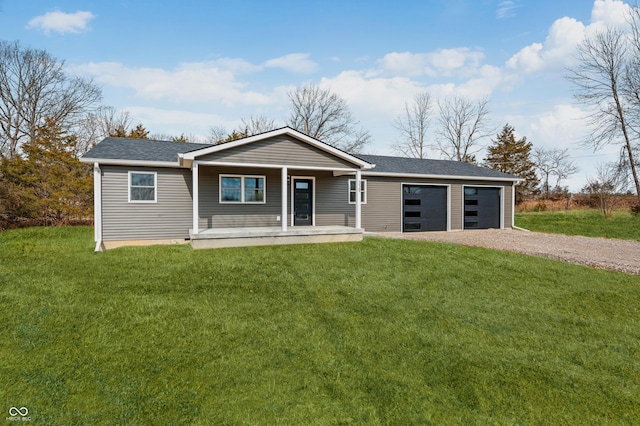 view of front of home with a porch, a garage, driveway, roof with shingles, and a front yard