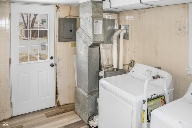 washroom with tile walls, washer / clothes dryer, electric panel, and light wood-type flooring