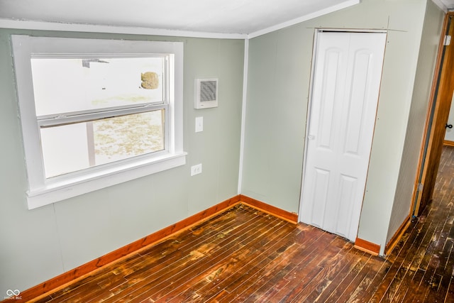 unfurnished bedroom featuring crown molding, dark hardwood / wood-style floors, and a closet