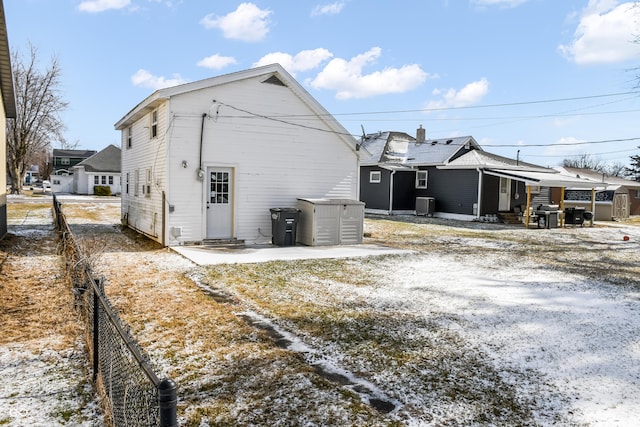 view of snow covered exterior with cooling unit