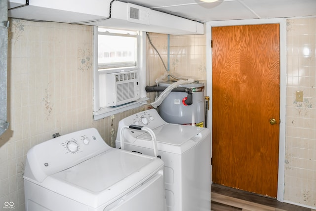 clothes washing area with washer and dryer, water heater, tile walls, and cooling unit