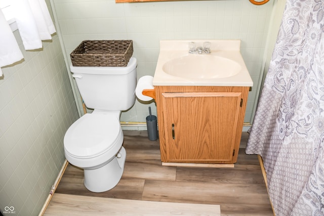 bathroom with vanity, hardwood / wood-style flooring, toilet, and tile walls