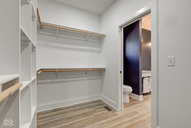 walk in closet with light wood-style flooring and visible vents