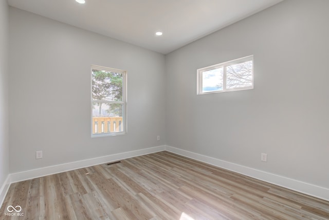 spare room featuring recessed lighting, light wood-style flooring, and baseboards