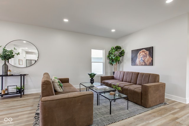 living room featuring baseboards, recessed lighting, and light wood-style floors