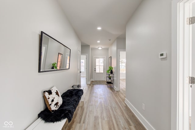 hall with light wood-style floors, recessed lighting, and baseboards