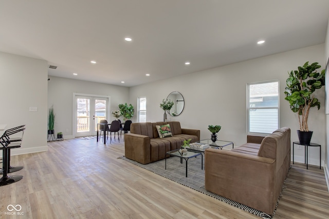 living area with light wood-type flooring and recessed lighting