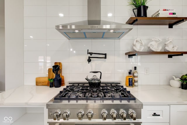 kitchen with open shelves, white cabinets, extractor fan, and decorative backsplash