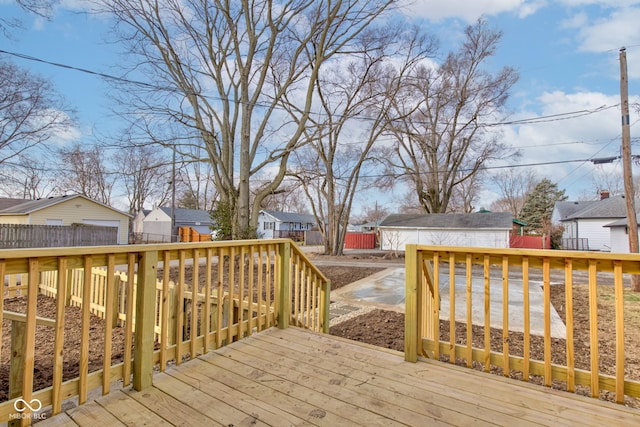 wooden deck featuring a residential view, fence, and an outdoor structure