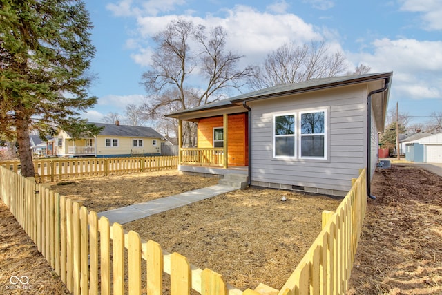 view of front of home with fence private yard, crawl space, and covered porch