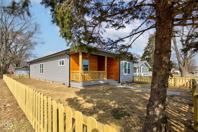 view of front of home featuring a porch, crawl space, and fence private yard