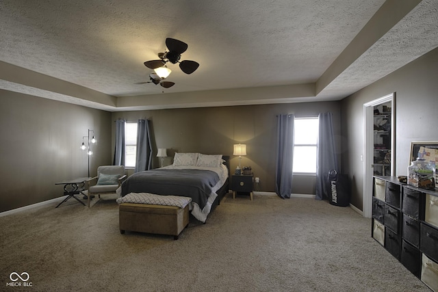 carpeted bedroom featuring ceiling fan and a textured ceiling