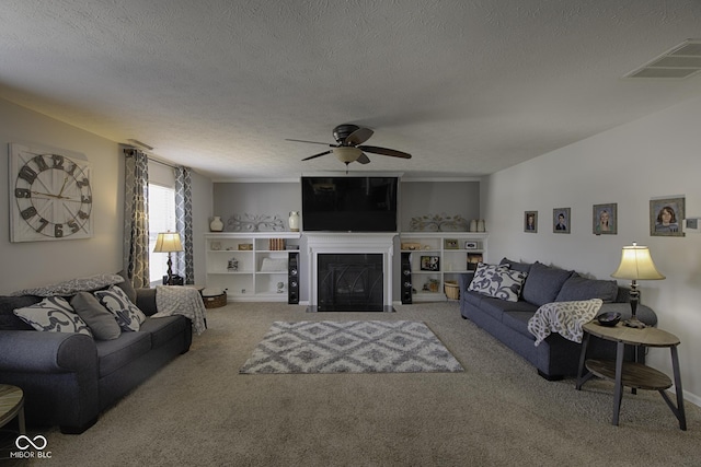 carpeted living room featuring ceiling fan and a textured ceiling