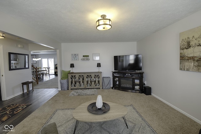 living room featuring a chandelier, dark hardwood / wood-style floors, and a textured ceiling