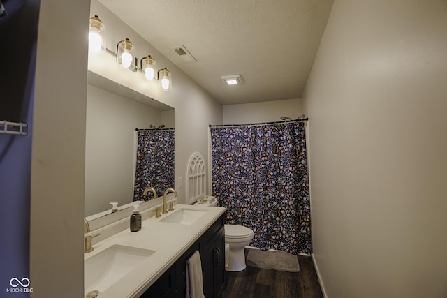 bathroom with walk in shower, toilet, wood-type flooring, a textured ceiling, and vanity