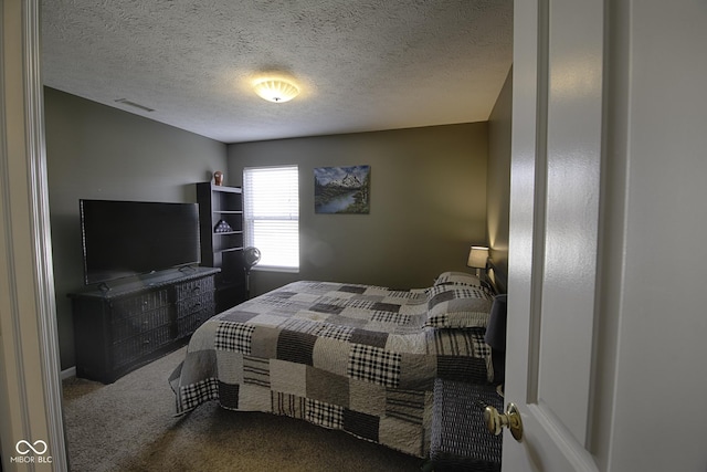 bedroom with carpet floors and a textured ceiling