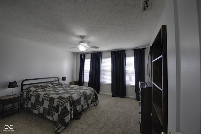 carpeted bedroom with ceiling fan and a textured ceiling