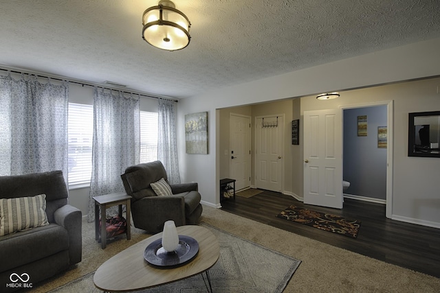 living room with dark hardwood / wood-style floors and a textured ceiling