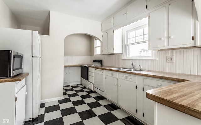 kitchen with sink, white appliances, and white cabinetry