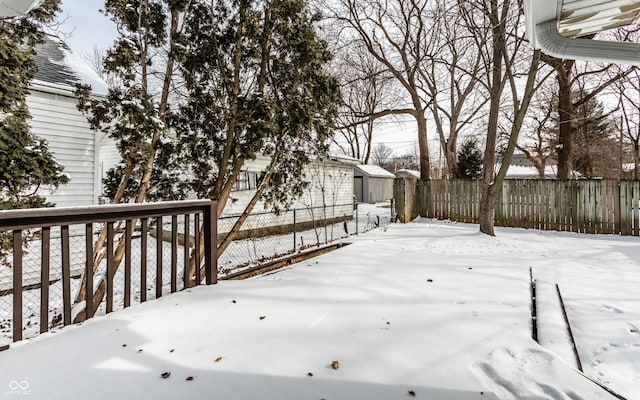 snowy yard with a storage shed