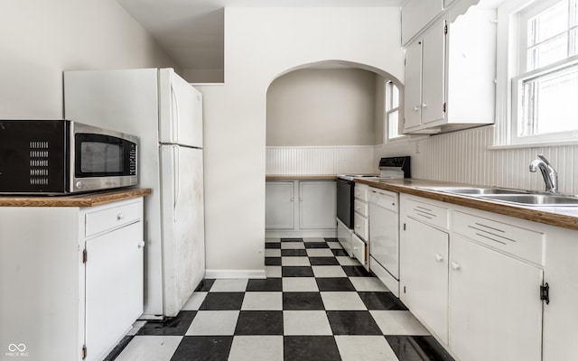 kitchen with white dishwasher, sink, range with electric stovetop, and white cabinets