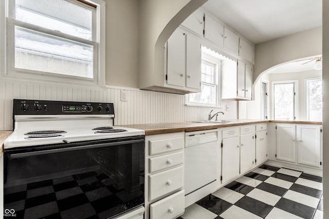 kitchen featuring range with electric stovetop, dishwasher, ceiling fan, sink, and white cabinetry