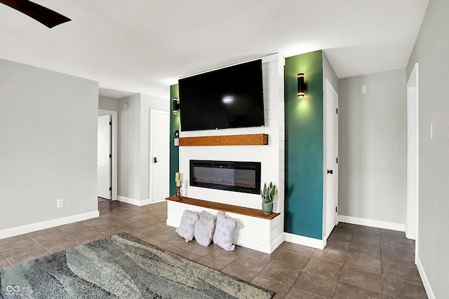 living room featuring a large fireplace, tile patterned flooring, and baseboards