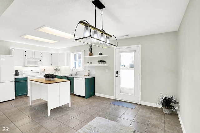 kitchen with white appliances, tasteful backsplash, a sink, open shelves, and green cabinetry