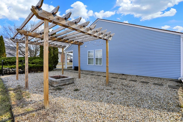 exterior space with a fire pit and a pergola