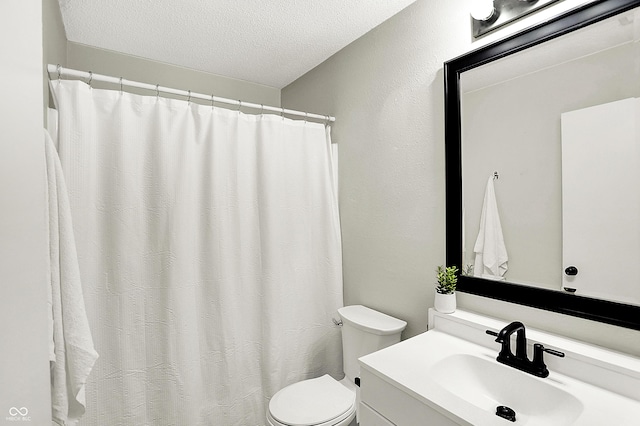 bathroom featuring a textured ceiling, vanity, and toilet