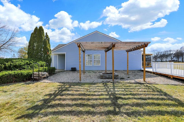 back of house with a carport, a deck, a pergola, and a yard