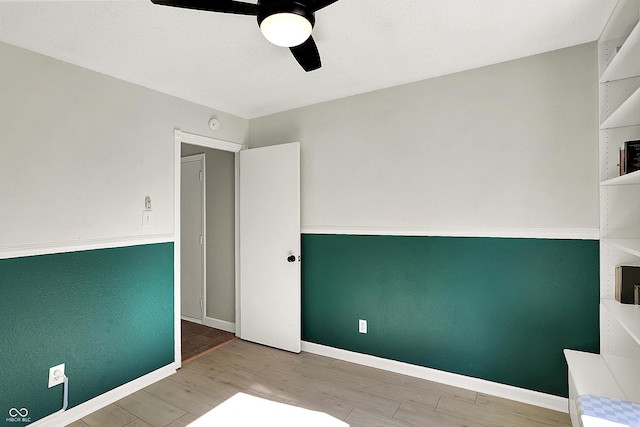 unfurnished bedroom with wood finished floors, a ceiling fan, and baseboards