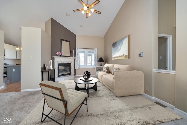 living room with visible vents, high vaulted ceiling, baseboards, light colored carpet, and a tile fireplace