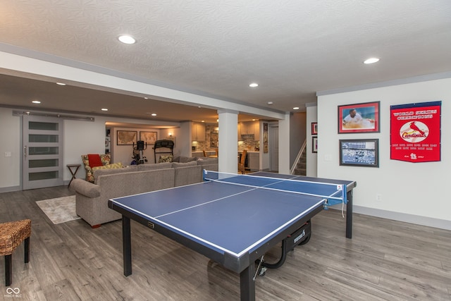 recreation room with recessed lighting, wood finished floors, baseboards, and a textured ceiling