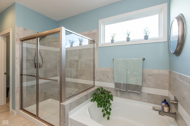 full bathroom featuring a shower stall and a garden tub