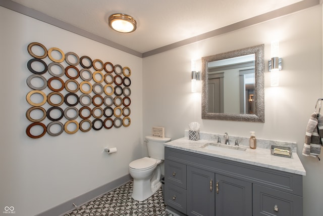 bathroom with vanity, toilet, and baseboards