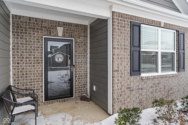 property entrance featuring brick siding