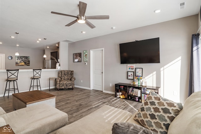 living room featuring baseboards, wood finished floors, visible vents, and recessed lighting