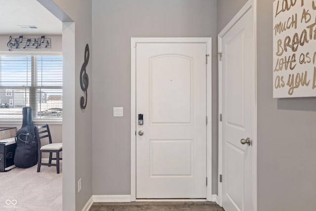 carpeted foyer with baseboards and visible vents