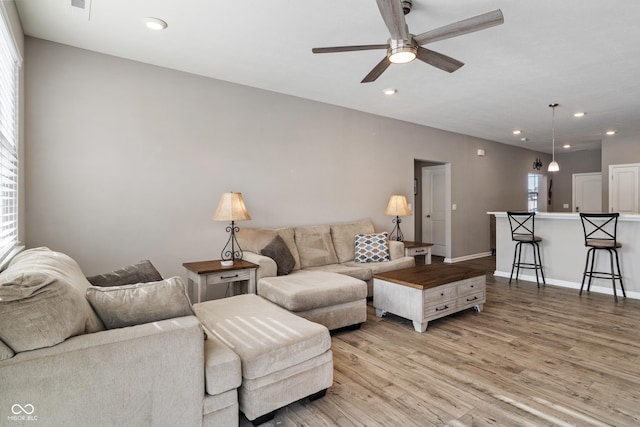 living area featuring a ceiling fan, recessed lighting, light wood-style flooring, and baseboards