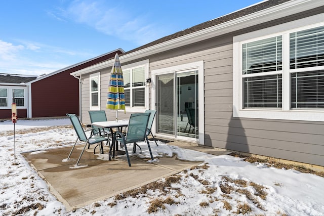 snow covered patio featuring outdoor dining space