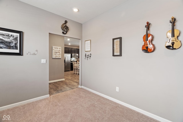 hall featuring light carpet, baseboards, and recessed lighting