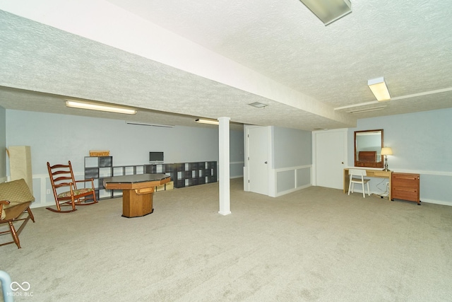 finished below grade area with a textured ceiling and carpet flooring